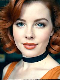 Woman in a bright orange 1950s dress with auburn hair repairs cars at the local garage